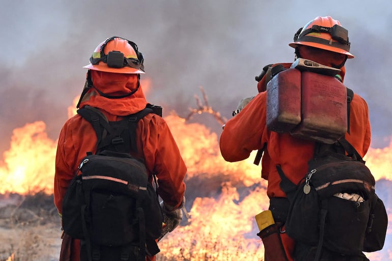 Un equipo de reclusos liderado por bomberos enciende las llamas mientras luchan contra el incendio Hughes cerca de Castaic, un vecindario del noroeste del condado de Los Ángeles, California.