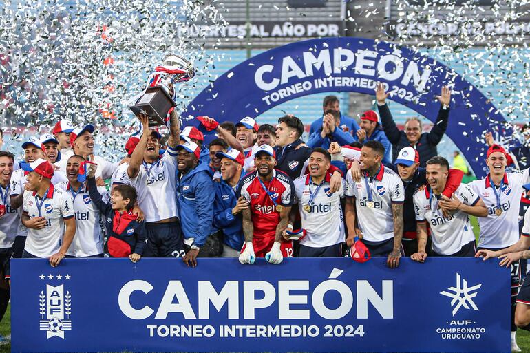 Jugadores de Nacional, entre ellos los paraguayos Federico Santander y Antonio Galeano, festejan al obtener el titulo del Torneo Intermedio del Campeonato Uruguayo este domingo, luego de derrotar al Club Atlético Peñarol, en el estadio Centenario, en Montevideo (Uruguay). EFE/ Gaston Britos