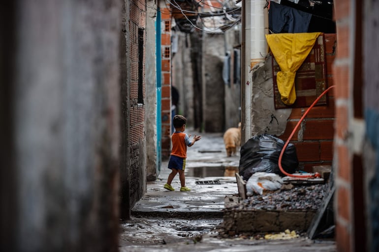 Un niño camina por una calle de la villa "Puerta 8" donde se vendió la cocaína adulterada que ya causo más de 20 muertos y 70 personas hospitalizadas, en Buenos Aires (Argentina).