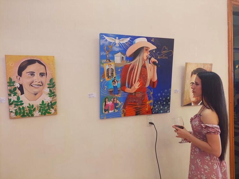 Deisy Espínola junto a los retratos de Marilina Bogado y la Beata Chiquitunga, ambas obras suyas. (Gentileza)