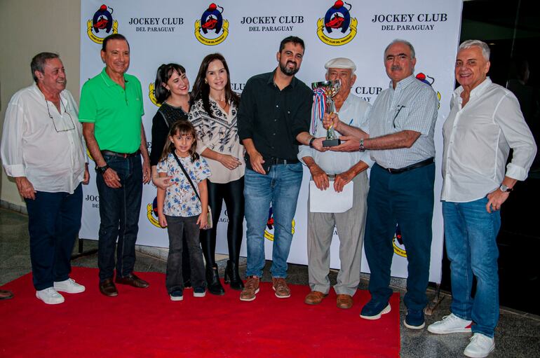 Luis María Maluff (d) recibe el trofeo en el premio "Homenaje a don Emhil Morel" por parte de familiares del extinto socio del Jockey Club del Paraguay, luego del triunfo de Perfume de Rosal.