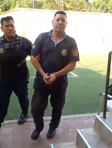 El guardiacárcel Nicolás Ovelar Toledo esposado, es conducido por un efectivo policial al calabozo de la comisaría 4ª de Asunción.