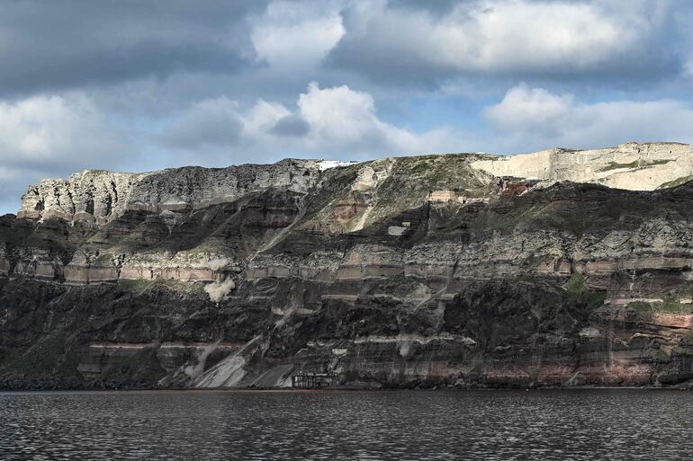 El 3 de febrero de 2025, la caída de rocas de los deslizamientos de tierra provocados por los temblores de tierra levanta nubes de polvo a lo largo de la pared rocosa del acantilado de la isla griega de Santorini.