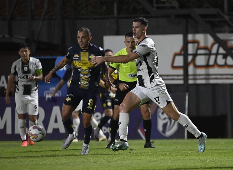 Luis de la Cruz, jugador del Sportivo Trinidense, disputa un balón con Nicolás Morínigo (d), futbolista de Tacuary, en un partido por el torneo Clausura 2024 del fútbol paraguayo en el estadio Martín Torres, en Asunción, Paraguay. 