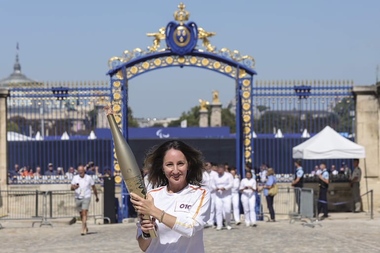 Directora de deportes de France TV, Celine Abisror Abbo lleva la llama Paralímpica con la compañía de una enfermera durante el Relevo de la Antorcha Paralímpica en los Inválidos de París, Francia, 28 de agosto de 2024.