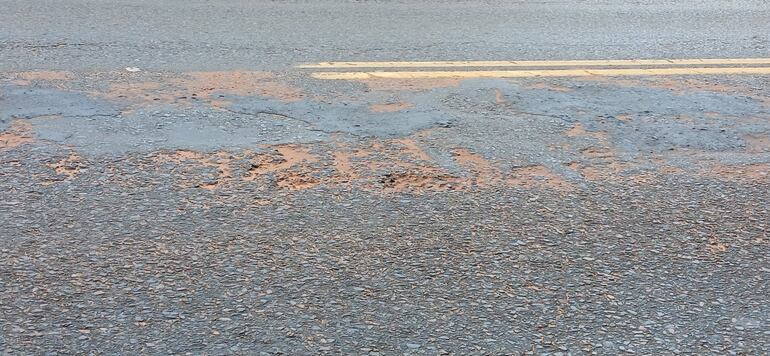 asfalto con baches y recapado en el medio