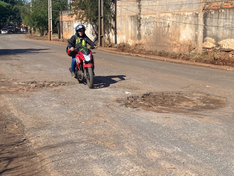 Motociclista tratando de esquivar grandes sobre la calle Tomás Ozuna.