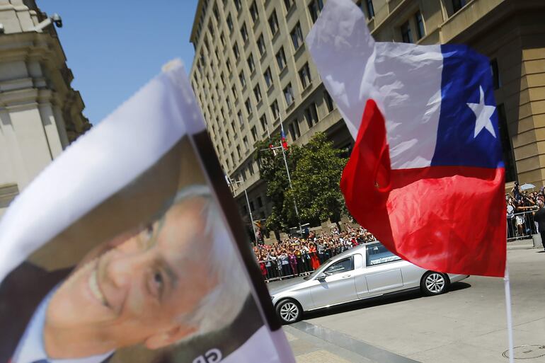 SCH01. SANTIAGO (CHILE), 09/02/2024.- Ciudadanos saludan el paso del cortejo fúnebre del expresidente Sebastián Piñera hoy, en Santiago (Chile). Sebastián Piñera falleció el pasado martes a los 74 años en un accidente de helicóptero. EFE/ Esteban Garay
