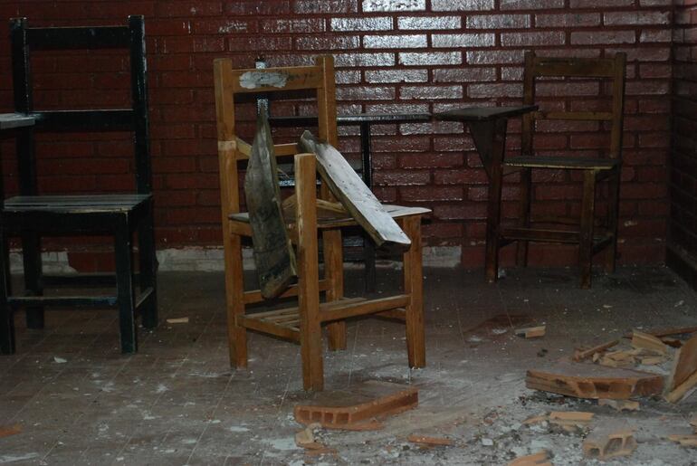 Silla rota y tejado caído en una institución educativa. (archivo).