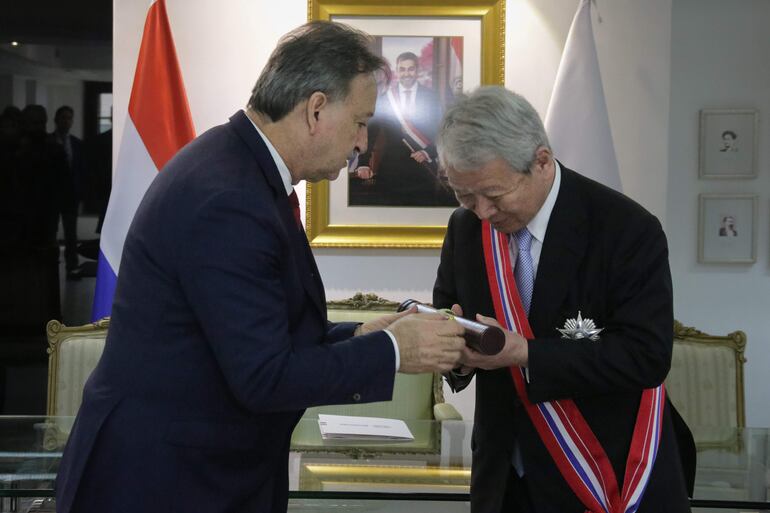 El viceministro de Relaciones Exteriores de Paraguay, Raúl Silvero (i), condecora al presidente de la Agencia Japonesa de Cooperación Internacional (JICA, por su sigla en inglés), Akihiko Tanaka, con la Orden Nacional del Mérito en el Grado de Gran Cruz del Gobierno paraguayo durante una reunión hoy, en Asunción (Paraguay). La  Agencia Japonesa de Exploración Aeroespacial (JAXA) brindará asistencia y capacitará a sus pares paraguayos en el uso de datos geoespaciales para mejorar la producción agrícola y la atención a desastres naturales, como parte de un acuerdo de cooperación suscrito este lunes por ambos países, informaron fuentes diplomáticas en Asunción. EFE.