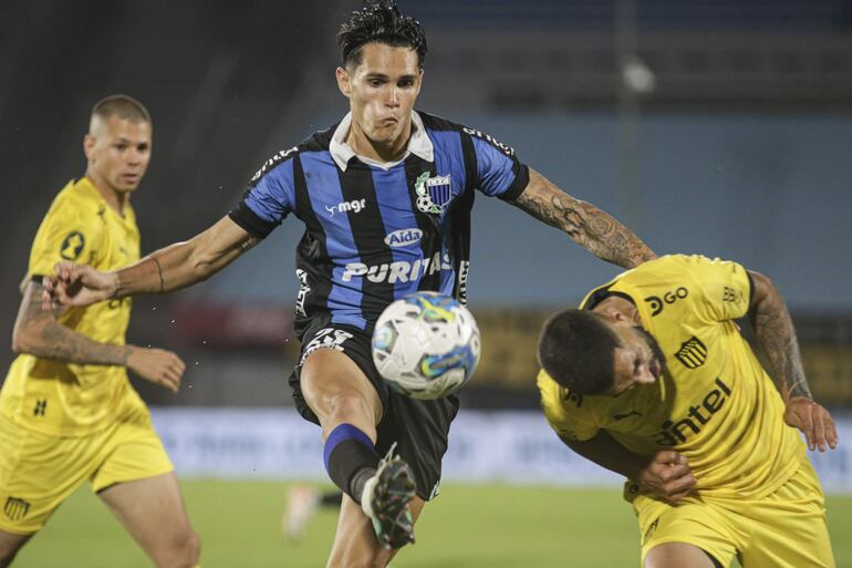 Rubén Bentancourt (c), autor de un un gol para Liverpool, disputa el balón con Maximiliano Olivera, de Peñarol. durante el partido final.