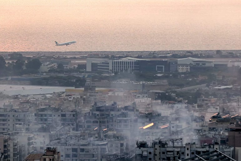 An aircraft of Middle East Airlines (MEA), Lebanon's flag carrier, takes off from Beirut International Airport on October 6, 2024 amidst smoke rising from nearby sites targeted overnight by Israeli air strikes in the southern suburbs of the Lebanese capital. (Photo by AFP)