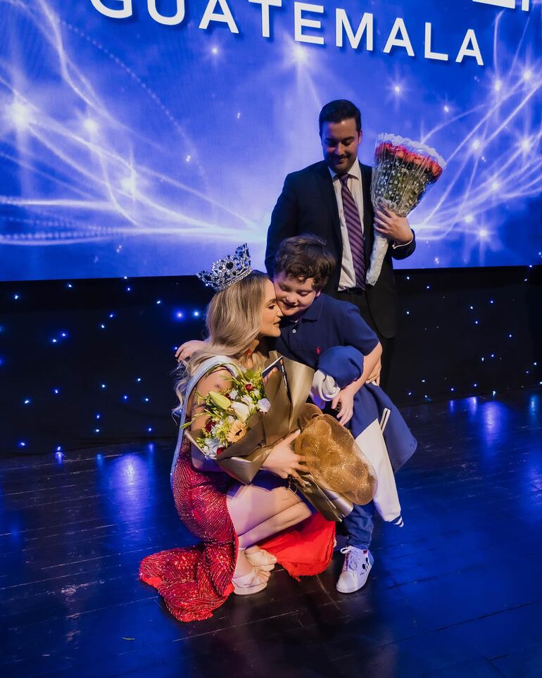 Michelle Cohn recibiendo el saludo de su hijo Luca ante la tierna mirada de su marido Andrés Matheu, tras alzarse con al corona de Miss Universo Guatemala 2023. (Instagram/Michelle Cohn)