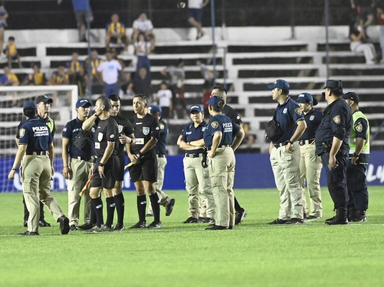 El árbitro Álvaro Giménez y los asistentes son rodeados por la policía después de finalizar el partido Sportivo Luqueño vs. General Caballero de Juan León Mallorquín por la duodécima fecha del torneo Clausura 2024 del fútbol paraguayo en el estadio Conmebol, en Luque, Paraguay.