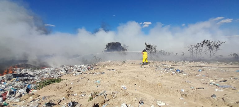 Un bombero de la compañía K55 de Pilar, intenta apagar el incendio en el vertedero municipal en la tarde de este domingo.