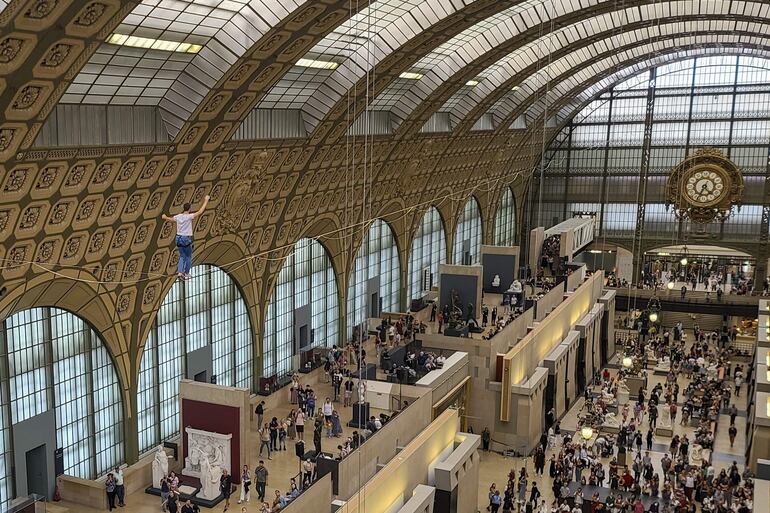 El funambulista Nathan Paulin cruza el techo de punta a punta del museo de Orsay de París, en un espectáculo de Rachid Ouramdane llamado 'Les Traceurs', que tiene lugar en la antigua estación ferroviaria con motivo de las jornadas europeas del Patrimonio.  
