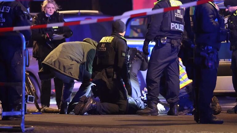 Captura que muestra a agentes de policía asistiendo a un hombre español apuñalado con un cuchillo junto al monumento a las víctimas del Holocausto este viernes, en Berlín (Alemania).