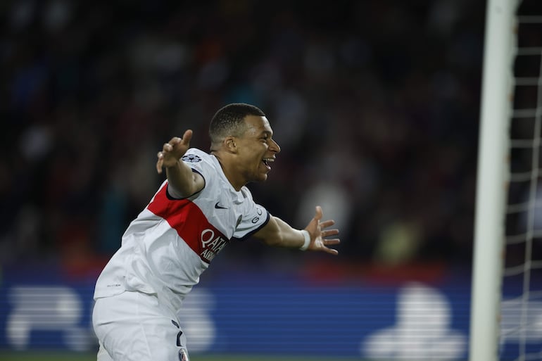 Kylian Mbappé (d), futbolista del París Saint-Germain, celebra un gol en el partido frente al Barcelona por la revancha de los cuartos de final de la Champions League en el estadio Olímpico de Montjuic, en Barcelona, España.
