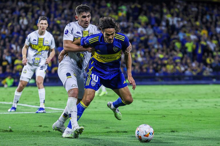 El uruguayo Edinson Cavani (d), jugador de Boca Juniors, disputa el balón con el paraguayo Juan Vera, futbolista de Sportivo Trinidense, en un partido de la Copa Sudamericana 2024 en el estadio La Bombonera, en Buenos Aires, Argentina.