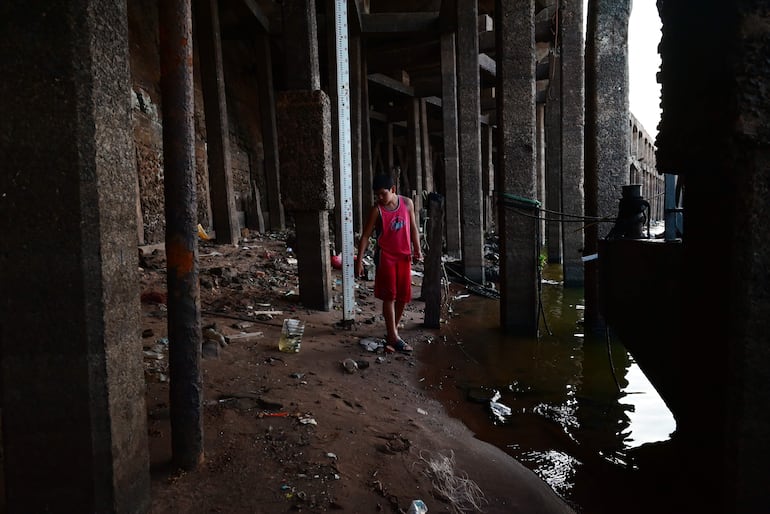 Pescadores en el lecho del río bajo el muelle del Puerto de Asunción, que está sin agua, buscando obtener alguna presa para cocinar en los días santos, en los que la iglesia católica propone la abstinencia de carne.