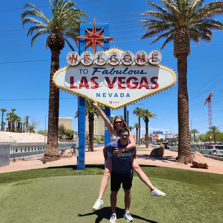 Gaby Mena y Christian Machuca posando felices frente al emblemático cartel de bienvenida a Las Vegas.