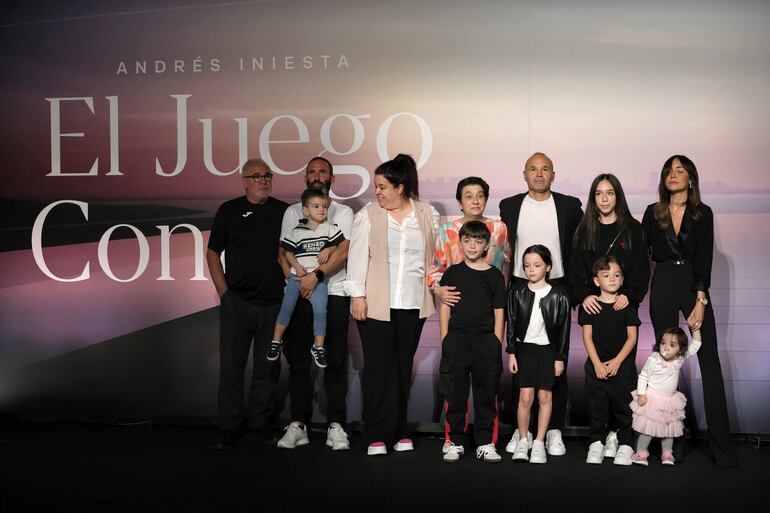 El futbolista español Andrés Iniesta rodeado de su esposa Anna Ortiz, sus cinco hijos, sus padres, su hermana y otros familiares tras anunciar su retirada a los 40 años durante un acto para celebrar su carrera en la sede de la America's Cup Experience de Barcelona. (LLUIS GENE / AFP)