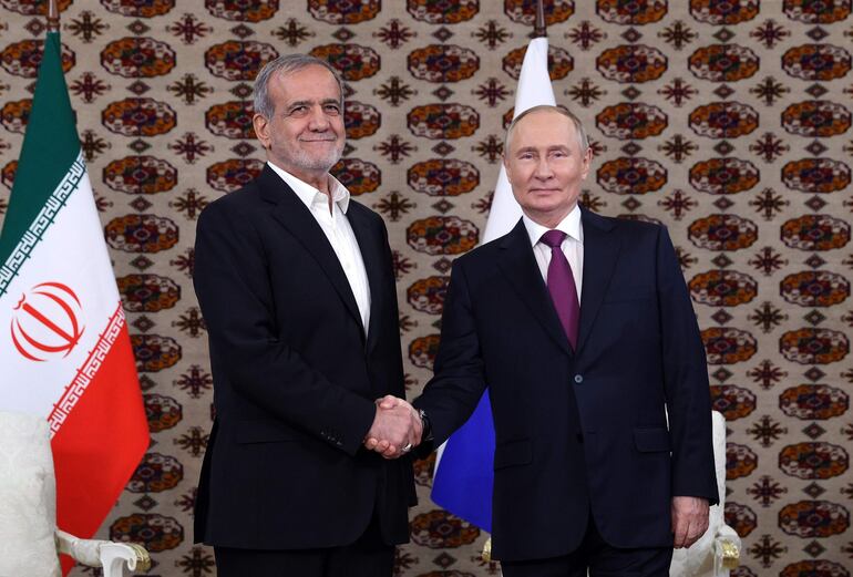 El presidente iraní Masoud Pezeshkian (i) y el presidente ruso Vladimir Putin (d), se dan la mano antes de una reunión en el marco del foro internacional 'Interrelación de épocas y civilizaciones: base para la paz y el desarrollo', en Ashgabat, Turkmenistán.