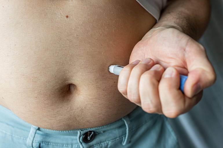 Una persona se inyecta Ozempic en el abdomen.