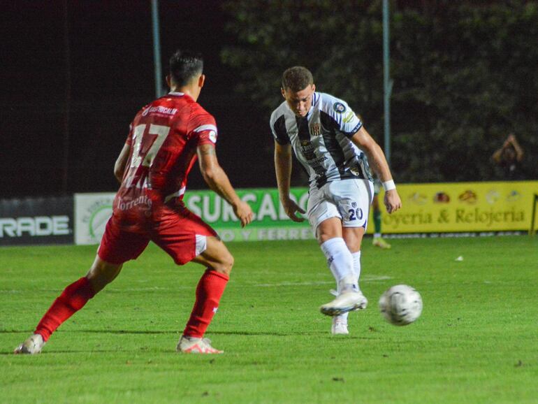 El volante albinegro, Ángel Colmán ejecuta el pase ante la presencia de Cristhian Riveros García (17). Foto: APF