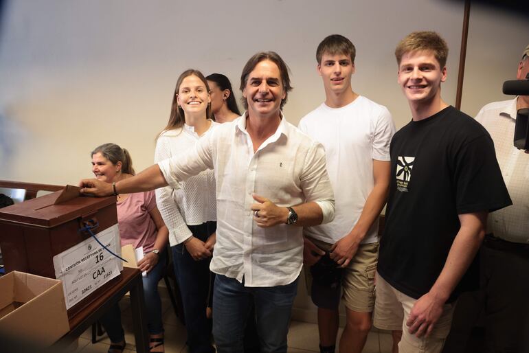 El presidente Luis Lacalle Pou junto a sus hijos, ejerce su derecho al voto en un colegio electoral, durante la segunda ronda de las elecciones presidenciales, este domingo, en la localidad de Canelones (Uruguay).