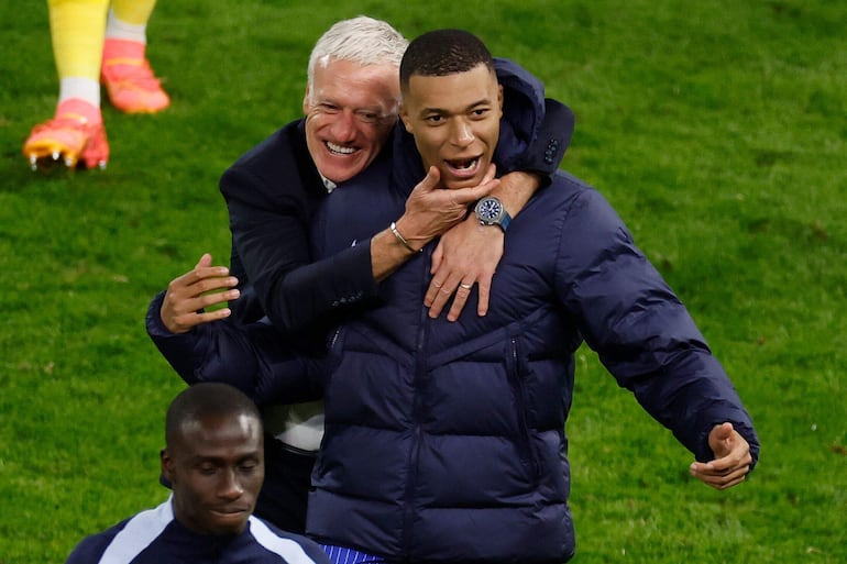 TOPSHOT - France's head coach Didier Deschamps and France's forward #10 Kylian Mbappe celebrate after winning the UEFA Euro 2024 quarter-final football match between Portugal and France at the Volksparkstadion in Hamburg on July 5, 2024. (Photo by Odd ANDERSEN / AFP)