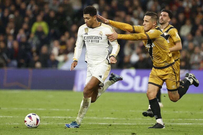 MADRID (ESPAÑA), 05/11/2023.- El centrocampista inglés del Real Madrid Jude Bellingham ante Oscar Trejo (d), delantero argentino del Rayo Vallecano durante el encuentro correspondiente a la jornada 12 de LaLiga que Real Madrid y Rayo Vallecano disputan este domingo en el Santiago Bernabéu. EFE/ Juan Carlos Hidalgo
