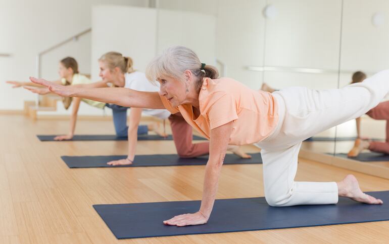 Un grupo de mujeres adultas mayores practica yoga.