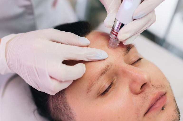 Cosmetóloga efectuando un tratamiento facial a un hombre. Foto: CCH Privé/EFE.