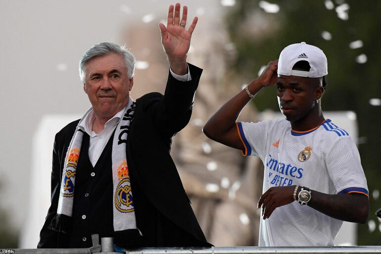 El entrenador italiano del Real Madrid, Carlo Ancelotti (i), y el delantero brasileño del Real Madrid, Vinicius Junior, hacen un gesto en la Plaza Cibeles de Madrid, después de que el Real Madrid CF ganara el partido de fútbol de la Liga española contra el RCD Espanyol el 30 de abril de 2022.