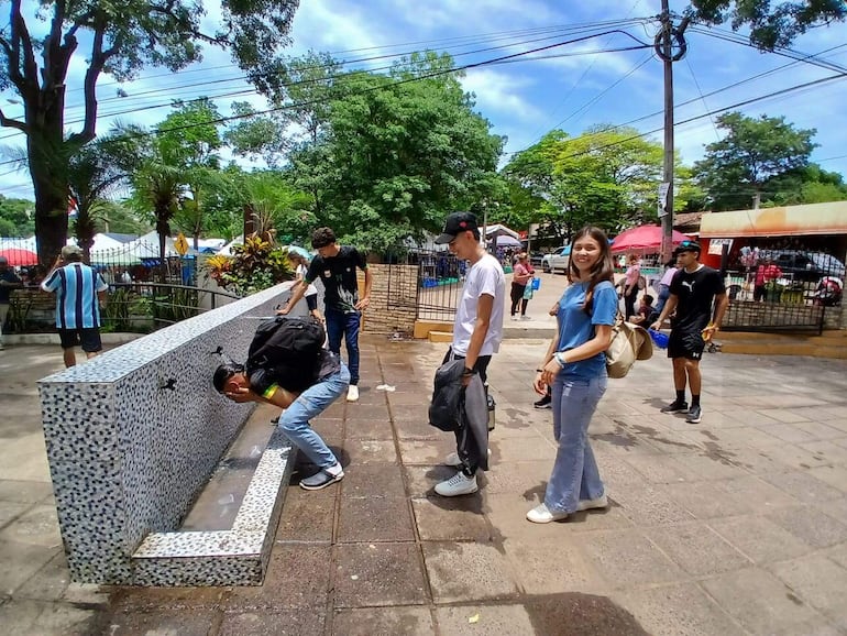 Peregrinos de Caacupé aprovechan para mojarse la cabeza y paliar el intenso calor.