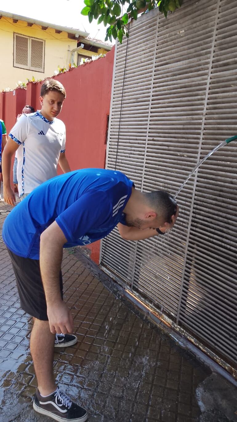 Un hincha se refresca gracias al agua de los vecinos de barrio Obrero.