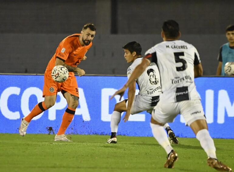 Lucas Pratto mete el balón en el área de Tacuary ante la marca de Domínguez y, más atrás, Cáceres