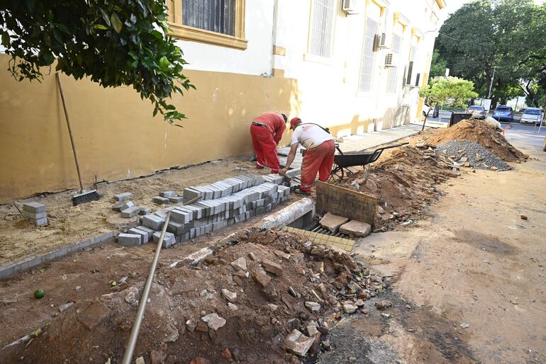 Obreros municipales colocan  los adoquines en la vereda de Nuestra Señora de la Asunción.