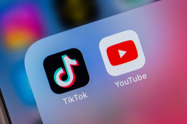 Logos de TikTok y YouTube en la pantalla de un teléfono celular.