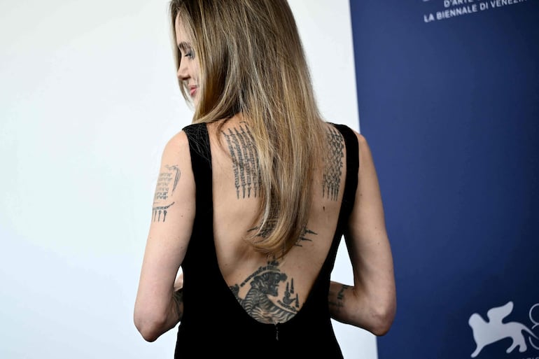 La actriz Angelina Jolie luciendo un impactante look que deja ver sus tatuajes en la espalda, durante el Festival de Cine de Venecia. El vestido fue confeccionado en el Atelier Jolie. (Marco BERTORELLO / AFP)