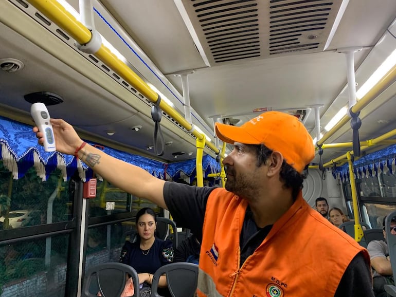 Un fiscalizador de Obras Públicas verifica la temperatura del aire acondicionado de un bus, mientras cumple su itinerario.