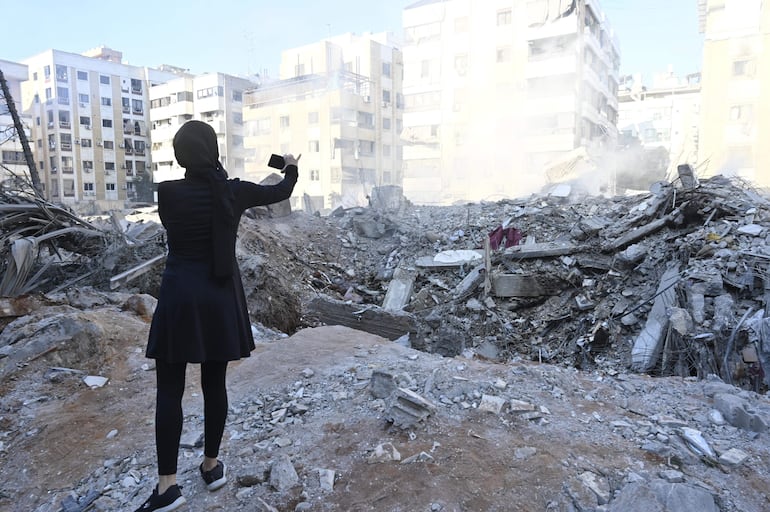 Una mujer toma una foto de un edificio destruido en el barrio de Haret Hreik, en los suburbios del sur de Beirut, tras los ataques militares israelíes sobre Beirut, Líbano, 29 de septiembre de 2024.