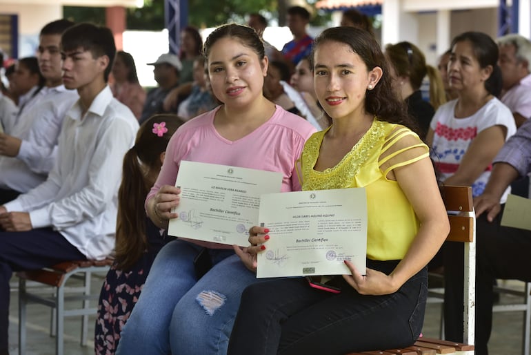 Liz (derecha) y su compañera Hilda muestran con orgullos sus cartones de egresadas del bachiller de educación para adultos en la escuela República de Cuba de Asunción.