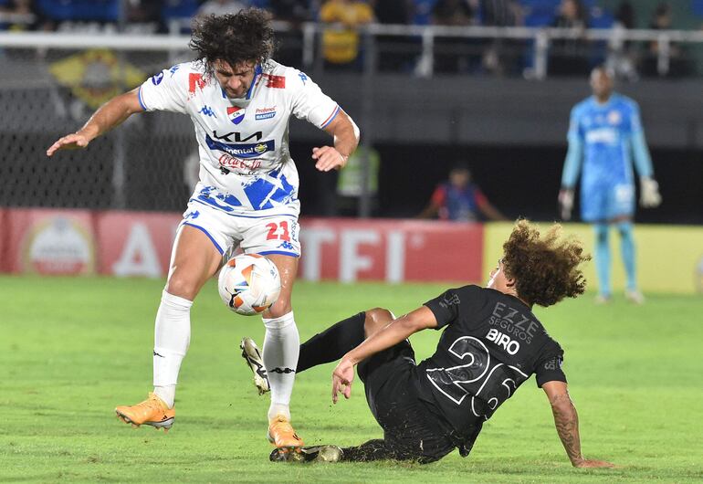 El paraguayo Blas Cáceres (i), jugador de Nacional, pelea por el balón en un partido frente al Corinthians por la Copa Sudamericana 2024 en el estadio Defensores del Chaco, en Asunción.