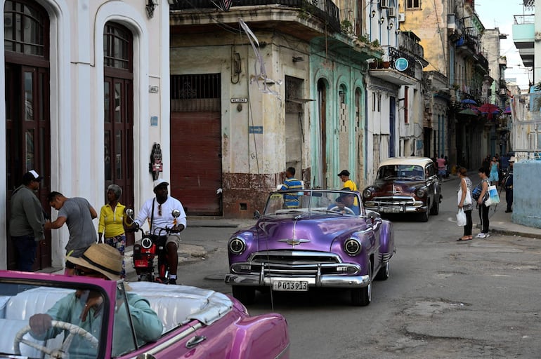 Viejos coches americanos circulan por una calle de La Habana. 