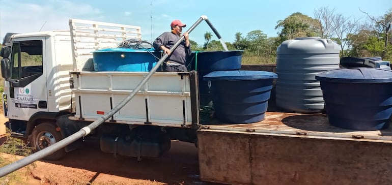 Un funcionario de la Gobernación de Caazapá carga los tanques para llevar a los usuarios.