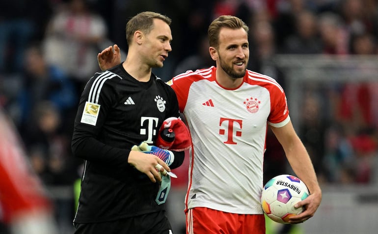 Manuel Neuer (i), quien reapareció ayer en la portería del Bayern, conversa con Harry Kane, quien se llevó la pelota a casa tras firmar un triplete en la victoria 8-0 sobre el SV Darmstadt 98