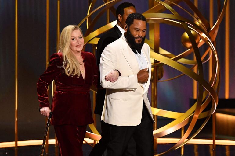 La actriz Christina Applegate ingresa del brazo del actor Anthony Anderson al escenario de la edición número 75 de los Premios Emmy en el Peacock Theatre de Los Ángeles.