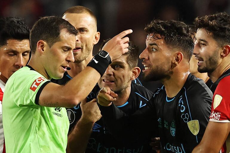 Gremio's midfielder Pepe (R) argues with Uruguayan referee Gustavo Tejera after he showed the red card to Gremio's Praguayan forward Mathias Villasanti during the Copa Libertadores group stage first leg football match between Argentina's Estudiantes de La Plata and Brazil's Gremio at the Jorge Luis Hirschi Stadium in La Plata, Argentina, on April 23, 2024. (Photo by ALEJANDRO PAGNI / AFP)